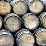 A collection of premium wooden whisky barrels, each elegantly marked with distinct numbers and text, meticulously arranged to showcase their investment value and quality.