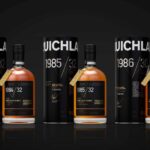 Three exquisitely displayed bottles of Bruichladdich Cask Whisky are accompanied by elegant black cylindrical boxes marked 1984, 1985, and 1986. These rare investment-grade vintages showcase the pinnacle of whisky craftsmanship and offer an unparalleled tasting experience, perfect for discerning collectors.