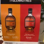This promotional display highlights whisky investment opportunities with two premium Glenrothes bottles: the 12 Years Old, priced at $188+, and the Whisky Maker's Cut at $248+. The featured display underscores the brand's high-quality allure and investment potential.