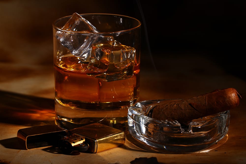whisky on ice in Crystal glass with cigar and zippo lighter