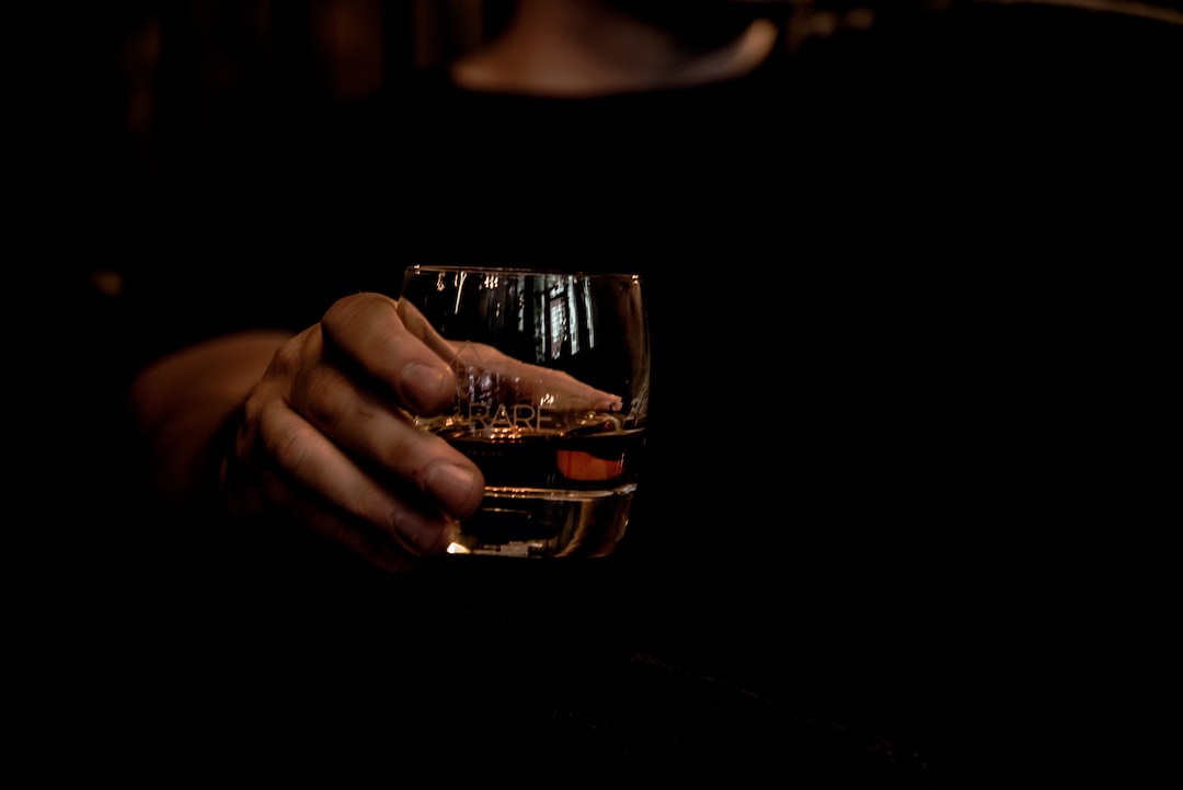 hand holding whisky glass and cigar