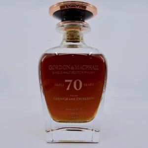 Behold the exquisite Gordon & MacPhail Single Malt Whisky, aged for an astonishing 70 years at the renowned Glen Grant Distillery. This high-value investment piece is adorned with a decorative cork and a label featuring elegant gold text, epitomizing luxury and quality craftsmanship in every drop. Perfect for discerning collectors who appreciate timeless elegance and exceptional taste.