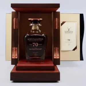 A premium 70-year-old Glen Grant single malt whisky is elegantly displayed in a glass decanter, housed within an open wooden box complete with an informative booklet nestled inside the lid.