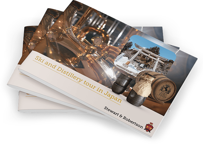 Stack of "Ski and Distillery tour in Japan" whisky tour booklets by Stewart & Robertson, showing distillery gear and a torii gate.
