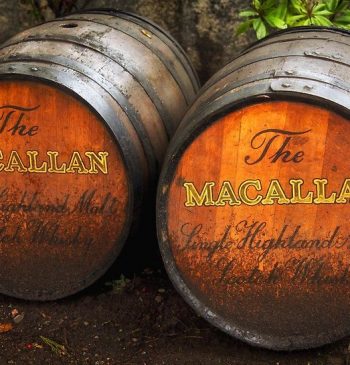 Two wooden barrels, prominently labeled "The Macallan," highlight the prestige of single Highland malt whisky, reflecting quality and high-value investment potential.