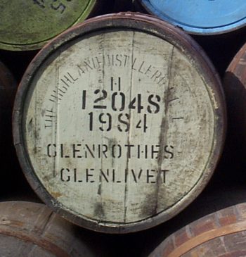 This image, perfect for a whisky investing website, features a wooden barrel inscribed with premium branding: "The Highland Distilleries 12048 1984 Glenrothes Glenlivet," symbolizing high-value investments and quality in the whisky market.